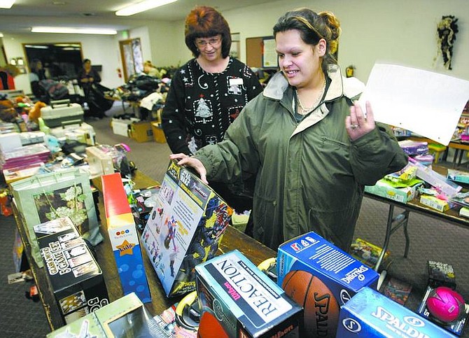 Cathleen Allison/Nevada Appeal Greater Nevada Credit Union volunteer Julie Moody, left, helps Angela Thrasher choose toys for her children Friday at the Salvation Army.