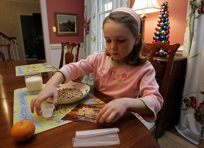 Gerry Broome/Associated Press Elizabeth White, 7, mixes peanut powder with a fruit roll-up before taking her daily dosage in Raleigh, N.C., Thursday. A study at Duke University is trying to help children with peanut allergies tolerate at least a little exposure.