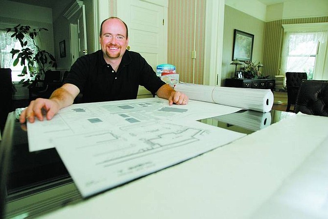 BRAD HORN/Nevada Appeal Phil Cowee, a new DRAC member, looks over plans of a Dayton Development, in his Minnesota Street office in Carson City on Wednesday.