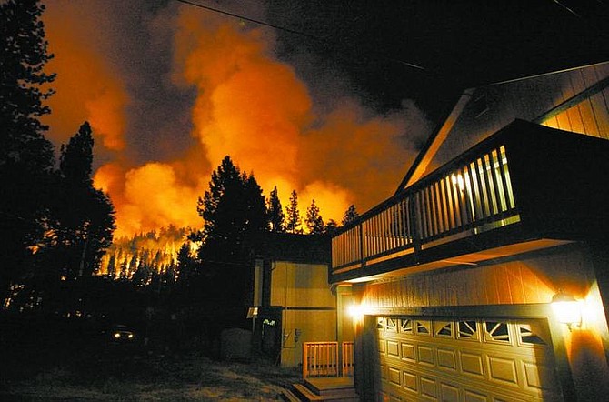 BRAD HORN/Nevada Appeal The Angora Fire burns near a home on Thirteenth Street in South The Angora fire continues to threaten some 500 homes in the Gardner Mountain area of South Lake Tahoe. This was a scene from early this morning.
