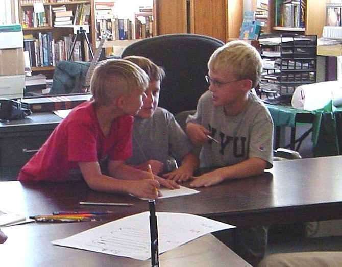 Mylo McCormick, Wyatt Smith and Cameron Ansart eagerly discuss their ideas for song lyrics during Chris Bayer&#039;s Lyric Writing Workshop for kids. Bayer will lead the workshop for the next six Thursdays in Silver City. The workshop is funded by the Nevada Arts Council and organized through Silver City&#039;s Case for Change and Healthy Communities Coalition of Lyon and Storey Counties.