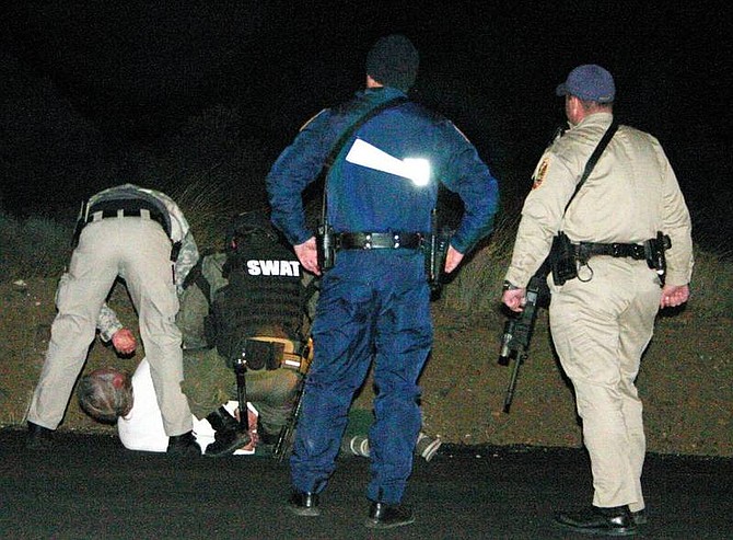 Jonni Hill/Nevada Appeal News Service Officers take down 60-year-old Topaz Ranch Estates resident Harry Sprouse after an hourlong armed standoff Wednesday.
