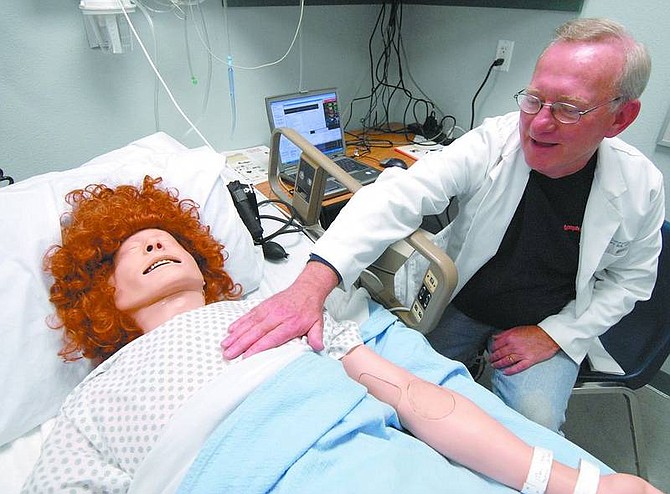 Kevin Clifford/Nevada Appeal Michael Malay, Western Nevada Community College nursing instructor, feels the heartbeat of SimMan on Wednesday afternoon in the Betty Ray and Locke Lesch Nursing and Allied Health Simulation Lab.