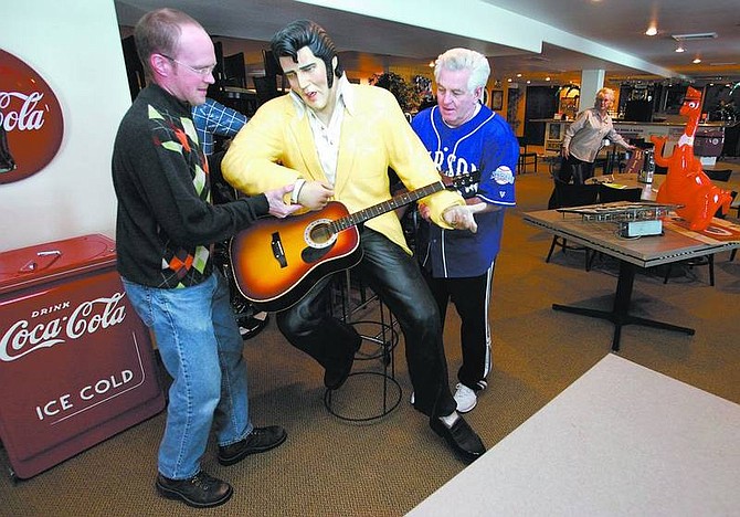 Cathleen Allison/Nevada Appeal Golf Pro Robert Mason, left, and Ron McNutt move an Elvis statue in the new event center at the Silver Oak Golf Course on Thursday afternoon. Coaches, the new restaurant and bar, is being decorated with 50s memorabilia from owner Garth Richards&#039; collection.