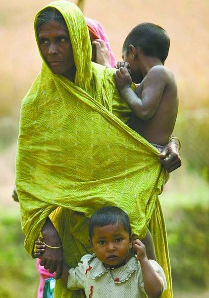 A Bangladeshi family stands near the road near Shariakandi, Bangladesh. Unemployment in Bangladesh hovers around 40 percent and 48 percent of all bangladeshi children are underweight for their age.