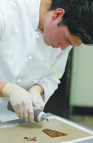Kevin Clifford/Nevada Appeal Mike Montio, a junior at Carson High School, makes chocolate decoration for a Touraine Cremets with Strawberry Coulis dessert during the fourth annual National Restaurant Association ProStart culinary competition Wednesday.