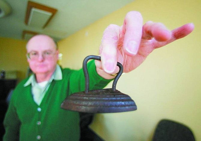 BRAD HORN/Nevada Appeal Ron Roberts displays an iron from Grandma&#039;s Trunk at the Nevada State Museum on Friday afternoon. The small iron was used for collars and ruffles. The museum is hosting an evening for educators Monday.