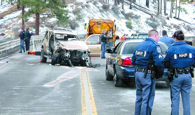 Kurt Hildebrand/Nevada Appeal News Service Nevada Highway Patrol troopers confer about an accident that occurred 7 a.m. Friday morning about seven miles up Kingsbury Grade from the intersection with Foothill Road. The accident involved three vehicles inculding a Nevada Department of Transportation snowplow and closed the grade for 3 1/2 hours.