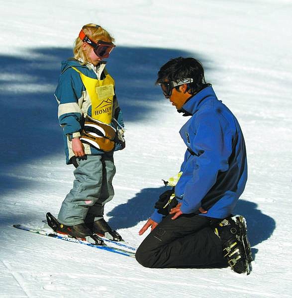 Emma Garrard/Appeal News Service Ignacio Vicente teaches Jenna Peterson to ski at Homewood Tuesday morning. Some resorts are cutting back on employee hours because of the lack of snowfall this winter.