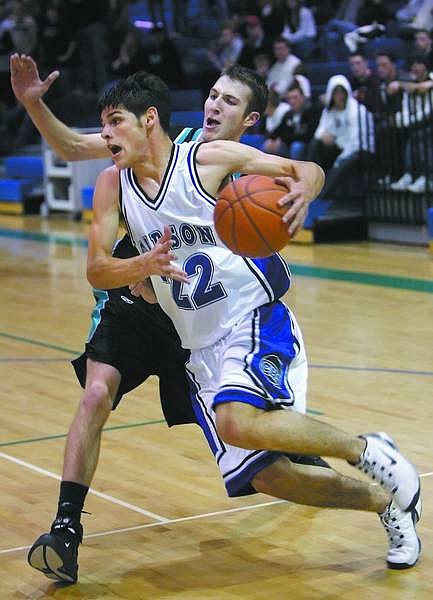 Chad Lundquist/Nevada Appeal Carson&#039;s Zack Weismann drives past North Valley forword Craig Davidson during Monday nights game at Damonte Ranch high school.
