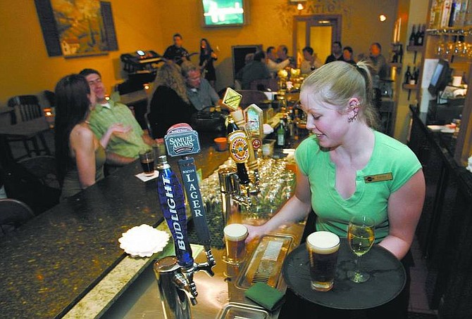 Cathleen Allison/Nevada Appeal Bartender Carissa Collins keeps busy Tuesday night in the recently remodeled bar at the Station Grille.