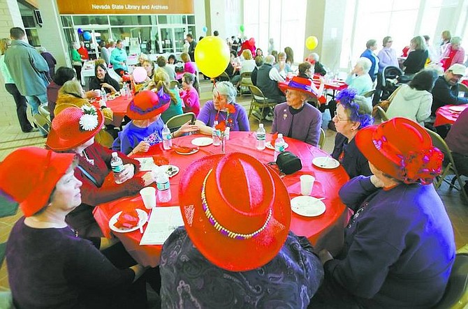 Members of the Red Hat Society finish eating an assortment of chocolate creations at the Nevada State Library and Archives building during the &quot;Feast of Chocolate&quot; annual fundraiser on Saturday.   BRAD HORN/Nevada Appeal