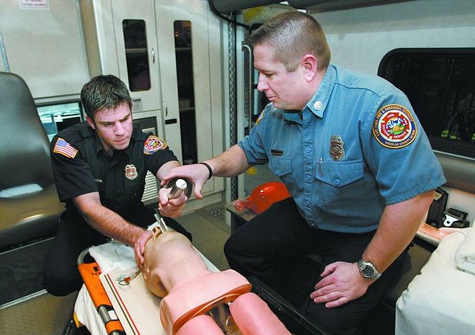 Cathleen Allison/Nevada Appeal East Fork Fire Capt. Dave Fogerson, right, watches firefighter/EMT Nick Hernandez practice intubation on a training dummy in Gardnerville. Fogerson teaches emergency medical procedures classes.