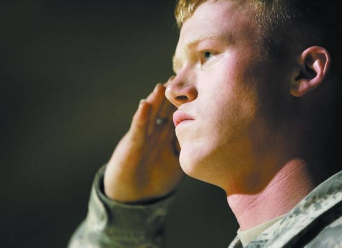 Chad Lundquist/Nevada Appeal Spec. Rick Cooley, a 2001 Carson High graduate, stands at attention during the national anthem at a Carson High basketball game on Feb. 6. Cooley is in the midst of a one-year deployment in Iraq, and said he still uses lessons he learned at Carson High.