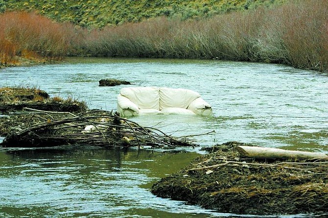 BRAD HORN/Nevada Appeal A junked sofa sits in the Carson River in Brunswick Canyon on Friday morning.