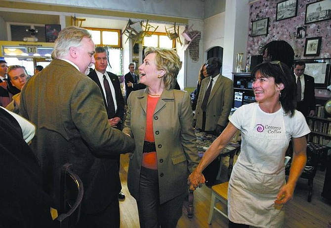 Cathleen Allison/Nevada Appeal Steve Platt, president of the Carson City Democratic Central Committee, left, greets U.S. Sen. Hillary Clinton, D-N.Y., as Comma Coffee owner June Joplin leads her around the shop on Wednesday. Democratic presidential candidates swept through Carson City on Wednesday for a forum and other campaign events.