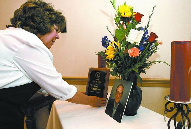 Cathleen Allison/Nevada Appeal Debbie Coyle, manager of the Plaza Conference Center, sets up a display before the memorial service held Tuesday for Edd Furgerson, a local developer who died Feb. 5.