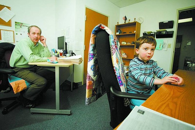 BRAD HORN/Nevada Appeal Mark Fitzsimmons, the subsidy program coordinator child care resource and referral department for the Children&#039;s Cabinet, has three sons. Trey, 4, is pictured with Fitzsimmons in his Carson City office on Friday.