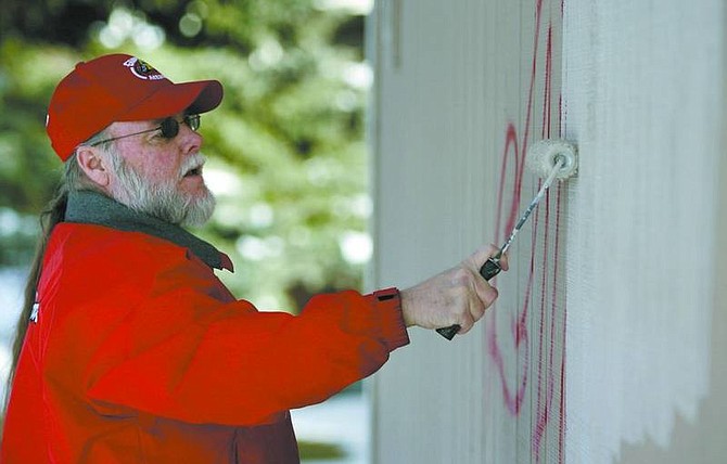 Cathleen Allison/Nevada Appeal Volunteer Marvin Inman paints over graffiti on Allouette Way on Wednesday afternoon.
