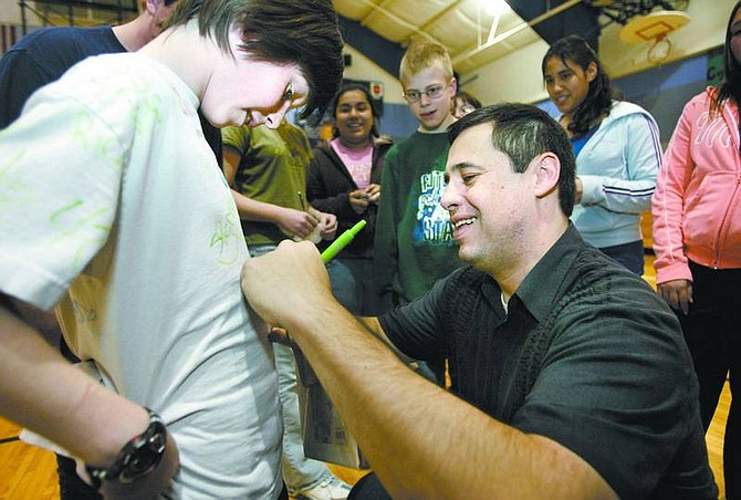 Cathleen Allison/Nevada Appeal Olympian Ruben Gonzalez autographs Ryan Sawyer&#039;s shirt at Dayton Intermediate School on Thursday. Sawyer, 11, thought it was &quot;pretty sick&quot; to meet Gonzalez, a former Olympic luger who now works as an inspirational speaker traveling the country encouraging people to read and to follow their dreams.