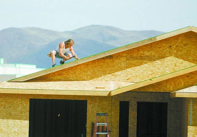 BRAD HORN/Nevada Appeal Dave Dubois works on the roof of his home in Dayton on Saturday. Federal government cuts have changed funding for CAHI families.