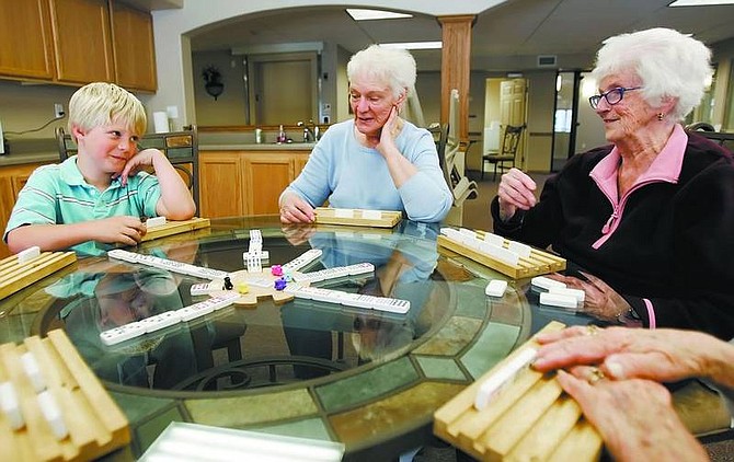 Connor Brown, 7, plays Mexican train with Flo Hobdy and Wilma Dunn at Autumn Village on Monday afternoon. Autumn Village Phase 1 is an affordable senior housing project that was completed in September. Phase II is under construction and should be completed by late July.    Chad Lundquist/ Nevada Appeal