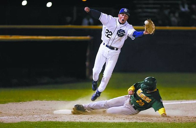 Chad Lundquist/Nevada AppealCarson&#039;s (22) Bryt Lewis jumps into the air while attempting to keep Manogue&#039;s (23) Craig Batory from stealing 3rd base during Tuesday nights game.