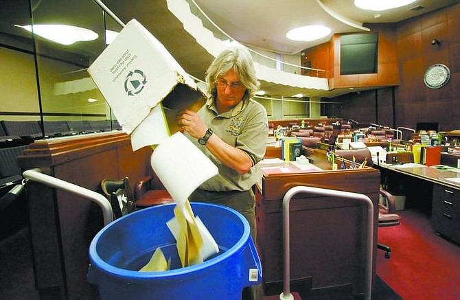 Mike      Hoffman dumps dead bills and other trash into a  trash can in the Assembly Chambers at the Nevada State      Legislature on Friday.  Brad Horn/ Nevada Appeal