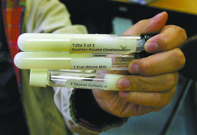 Carlos Osorio/associated press Clague Middle School student Heonseung Jee holds test tubes containing representative samplings of fat that can be found in a quarter-pound cheeseburger, a cup of whole milk and 10 saltine crackers in his classroom in Ann Arbor, Mich., on April 5.