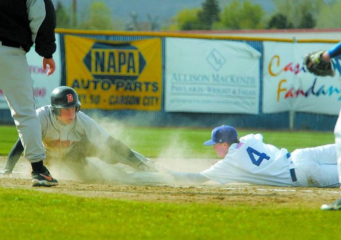 BRAD HORN/Nevada Appeal Carson&#039;s Kyle Stone reaches to tag Douglas High&#039;s Willie Morgan on a past ball during the 6th inning in Carson on Thursday.