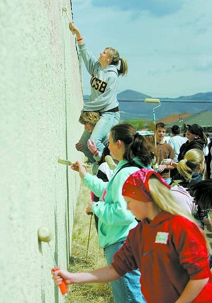 BRAD HORN/Nevada Appeal Alicia Dreyer, 16, paints while on Kelly Sullivan&#039;s shoulders during Graffiti Cleanup Day in Carson City on Saturday.