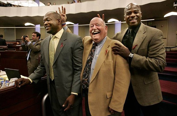 Cathleen Allison/Nevada Appeal  Nevada Assemblymen, Bernie Anderson, D-Reno, center and Kelvin Atkinson, D-North Las Vegas, right, help Assemblyman William Horne, D-Las Vegas, as he tries to give a media interview Friday afternoon on the Assembly floor at the Legislature.