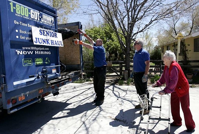 Chad Lundquist/Nevada Appeal Esther Humphrey, 97, watches as David Bouino and Mark Johnston from 1-800-Got-Junk?, pick-up yard trimmings from her home in North Carson City on Monday. The company is providing free service to elderly and disabled people as part of Carson Pride Week.