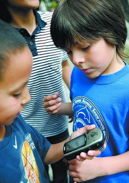 Chad Lundquist/Nevada Appeal Julian Alvarado and Daniel Martinez, both 9, study a handheld GPS device outside Bordewich-Bray Elementary school on Wednesday afternoon as part of the school&#039;s Gifted and Academically Talented Exploration program.