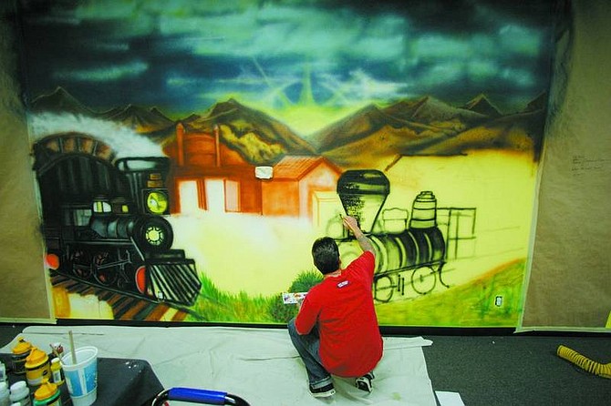 BRAD HORN/Nevada Appeal Terry Benson works on his V&amp;T Railroad-themed mural at Curves in Dayton on Saturday afternoon.