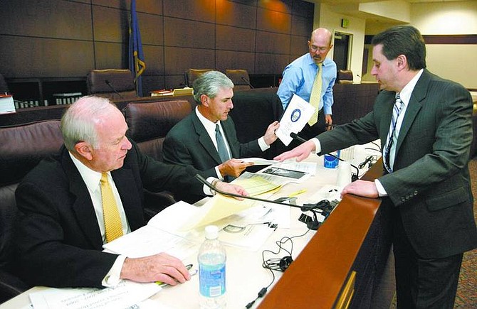 Legislative analyst Russell Guindon, right, talks with Economic Forum members, from left, William Martin, Michael Small and Cary Fisher on Tuesday at the Legislature. The forum says revenue  projections show there may be a need for cuts, possibly $75    million beyond the more than $100 million in   reductions already being proposed.  Cathleen Allison/ Nevada Appeal
