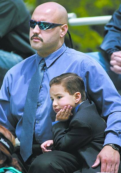 Cathleen Allison/Nevada Appeal Carson City Sheriff&#039;s Deputy Jose Gomez and his son Cory, 4, watch the Law Enforcement Officers Memorial Ceremony on Thursday afternoon.