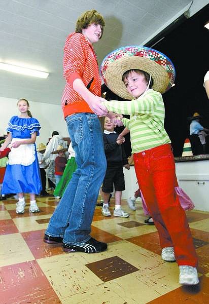 Cathleen Allison/Nevada Appeal Kindergartner Ellen Bayliss, 6, dances La Tapatia with Griffin Wilcher, 13, Friday at St. Teresa of Avila Catholic School. The students performed the hat dance as part of a Cinco de Mayo celebration.