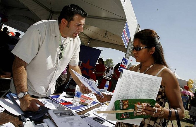 Isaac Brekken/Associated Press Nevada State Democratic Party outreach director, Andres Ramirez gives leaflets and voter registration information to Claudia Ruiz during a Cinco De Mayo celebration in Las Vegas on April 29. There is no Spanish word for &quot;caucus&quot; and that is just one of Ramirez&#039;s problems as the outreach director responsible for selling the Nevada Democratic presidential caucus to the state&#039;s large and underrepresented Hispanic population.
