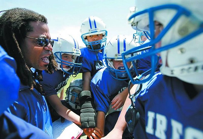 Chad Lundquist/Nevada Appeal Israel &quot;Coach Papa&quot; Lewis gives his players last minute advice before their Scholars and Champions Youth Football League game against the USC Trojans on Sunday.