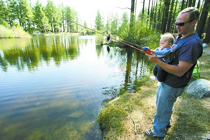 BRAD HORN/Nevada Appeal file photo Shawn Euse, 8 months old, helps his father Jay, of Virginia City Highlands, fish at the 2006 Tommy&#039;s Fishing Derby at Davis Creek State Park.