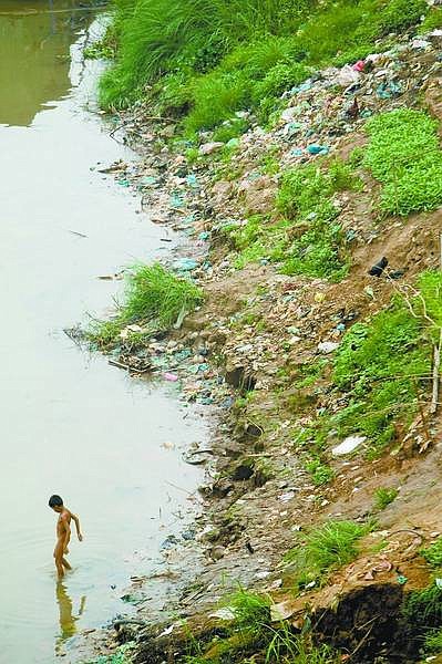 Rick Gunn/for the Appeal A young boy descends into the Mekong River near Phnom Penh, Cambodia, for his morning bath.