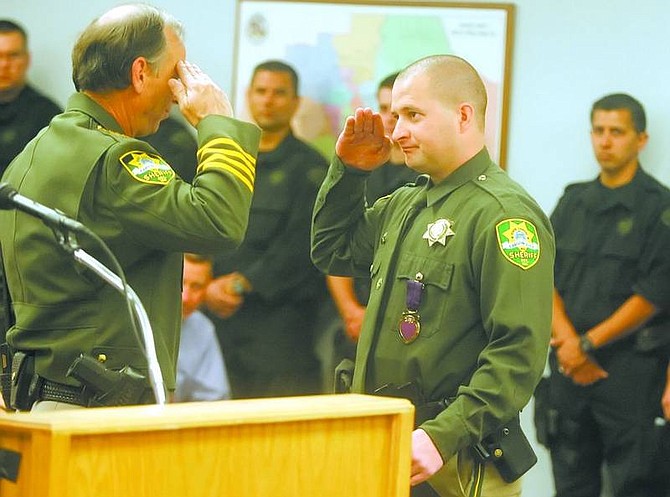 BRAD HORN/Nevada Appeal Carson City Sheriff&#039;s deputy Josh Stagliano salutes Sheriff Kenny Furlong after receiving a Purple Heart at the Carson City Community Center on Thursday morning.