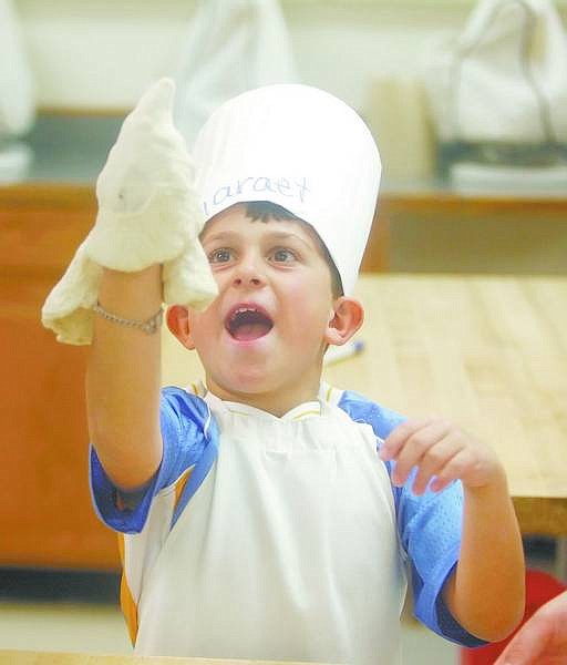BRAD HORN/Nevada Appeal Geraet Rauh, 8, a second-grade student at Bordewich-Bray Elementary School, attempts to spin his pizza crust during a cooking session with Carson High School culinary students on Thursday at the high school.