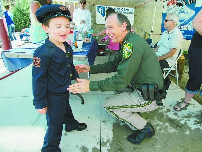 BRAD HORN/Nevada Appeal Carson City Sheriff Kenny Furlong puts a sheriff&#039;s star on Walter Cruz, 4, of Carson City, on Saturday at the fourth annual Cops and Kids Sheriff&#039;s Open House. Cruz said he wants to be a police officer.