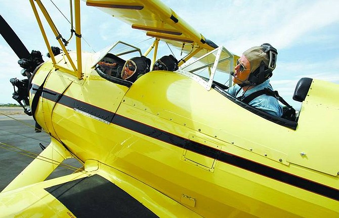 Photos by Chad Lundquist/Nevada Appeal Marti Gray, of Silver Springs, waves to friends before taking off for a ride with Pilot Randy McLain in his biplane on Sunday during the Lyon County Fly-In in Silver Springs.