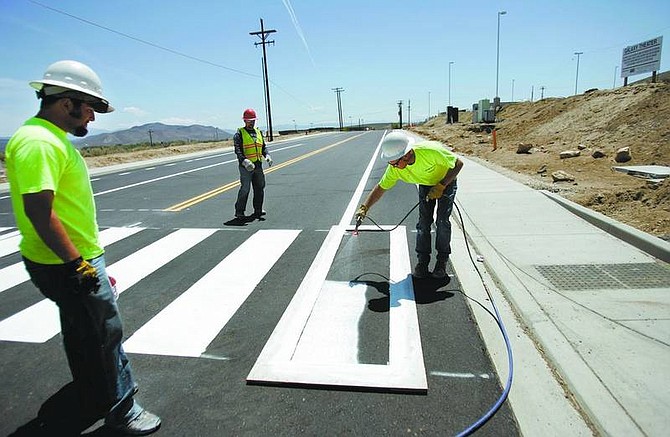 Chad Lundquist/Nevada Appeal A paint crew from Intermountain Slurry Seal, Inc., applies pavement striping on South Curry Street on Monday afternoon.