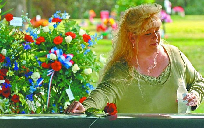 Don Burk/The Florida Times-Union Lori Ann McCormick, places a single rose on the casket of her son Pvt. Clinton Tyler McCormick following his funeral Jan. 6 in Jacksonville, Fla. McCormick, 20, was killed in Iraq on Dec. 27.