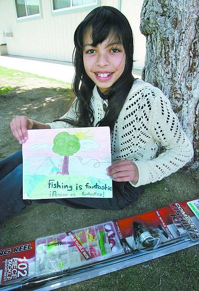 Jezalea Segura, 10, shows the artwork she created for the Nevada Department of Wildlife Free Fishing Day Poster Contest. Jezalea, who won a fishing kit for her first-runner-up entry, hopes to try fishing for the first time this summer. Cathleen Allison/Nevada Appeal