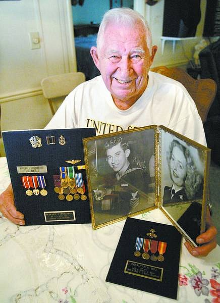 Cathleen Allison/Nevada Appeal Howard Spreeman, president of the Pearl Harbor Survivors Silver State Chapter, shows photographs and service medals from he and his wife, Rosalynn&#039;s, military careers.